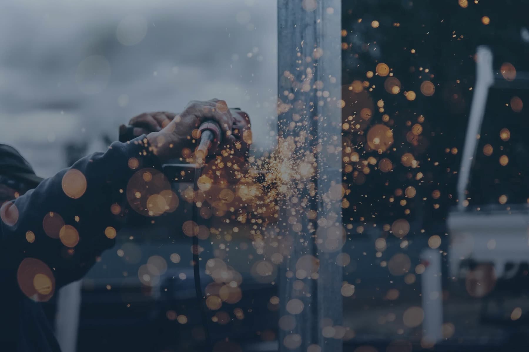 Sparks flying from a grinder during a structural steel installation on a BAWE site